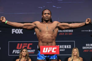 UFC拳手在稱重活動中張開雙臂在體重磅上擺姿勢。