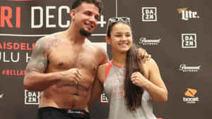 一名男拳手和一個小女孩在Bellator活動中一起擺姿勢。