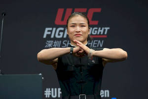 UFC拳手在記者會上雙臂交叉身穿黑色服裝。