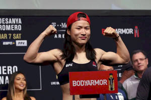 UFC拳手在稱重活動中展示肌肉並手持BodyArmor標誌