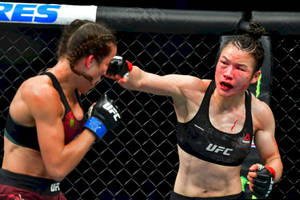 兩名女性拳手在UFC八角籠比賽中互相出拳，可見血跡。 — 動漫打鬥 壁紙