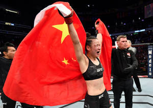UFC拳手披著中國國旗在八角籠中慶祝勝利。