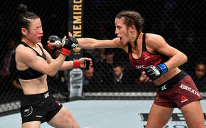 兩名女性MMA拳手在UFC比賽期間於鐵籠中互相出拳。