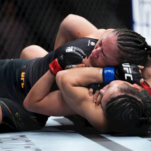 兩位女性拳手在UFC比賽中處於纏鬥狀態。