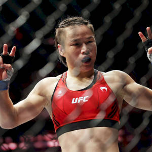 女性MMA拳手在UFC八角籠內舉手慶祝勝利。