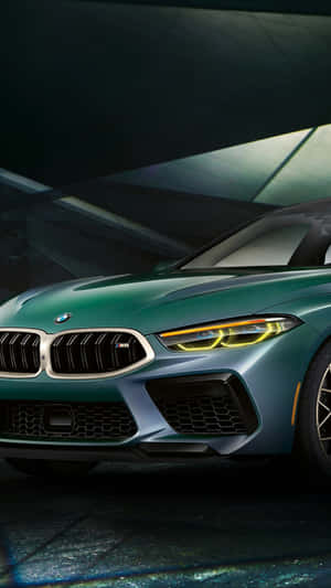 在黑暗的工作室環境中，一輛綠色BMW M8跑車配備發光的頭燈。