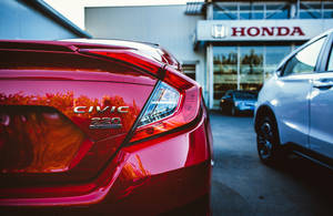 紅色Honda Civic 220 Turbo泊喺陳列室，附近有白色車。