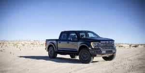 黑色福特 F-150 Raptor 在黃昏時停泊在沙漠小徑上。