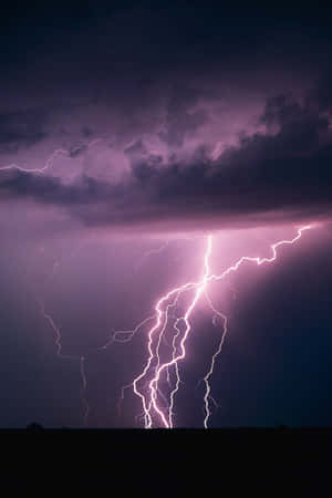 紫色閃電照亮了黑暗景觀上方的暴風雨夜空。