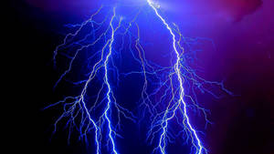 強烈的藍色閃電照亮了帶有紫色色調的黑暗暴風雨天空。