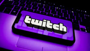 智能手機在筆記型電腦上顯示 Twitch 標誌，帶有紫色光芒