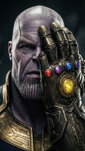 身穿盔甲的薩諾斯手持帶有發光寶石的無限手套 — Thanos 壁紙