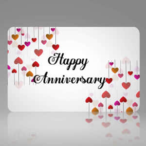 Happy Anniversary 卡片，在反光表面上掛有彩色心形裝飾。