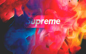 Supreme標誌被旋轉的紅色、藍色和黃色墨水包圍在黑色背景上