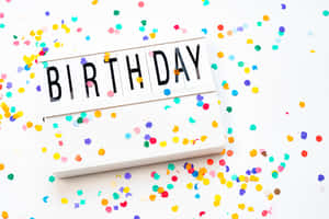 生日燈箱，周圍散落著彩色紙屑。