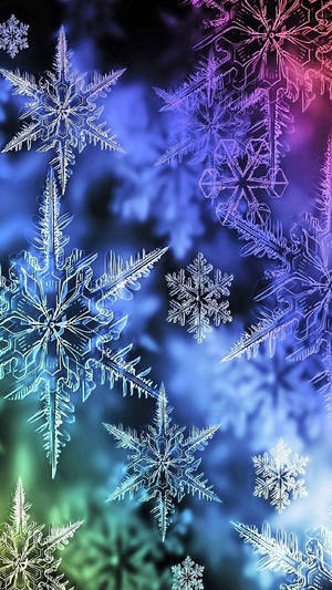 發光的雪花漂浮在色彩繽紛的漸變天空中，帶有藍色、紫色和綠色色調。