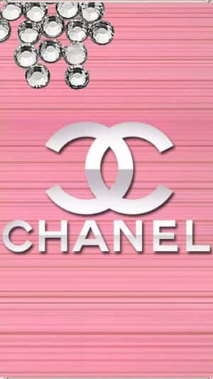 帶有銀色 Chanel 標誌和水鑽的粉紅色紋理背景。