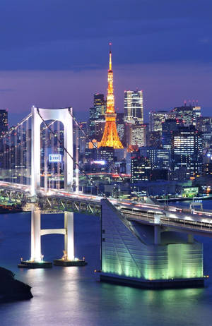 彩虹橋和東京塔在東京的水面上夜晚亮燈。 — 日本 壁紙