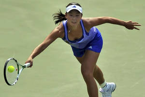 女網球選手在綠色球場上猛衝擊打黃色球。 — 網球 壁紙