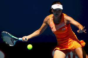身穿橙色運動服的女性網球選手用球拍擊球。 — 網球 壁紙