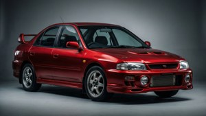 紅色Subaru Impreza WRX STI轎車，帶有性能改裝，在攝影棚燈光下。