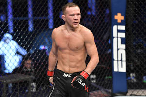 一名赤裸上身的MMA拳手穿著UFC裝備，在八角籠內進行比賽。