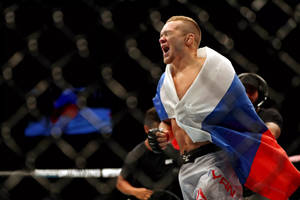 MMA拳手披著俄羅斯國旗在八角籠中慶祝勝利。