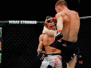 兩名男性拳手在MMA籠內比賽中激烈纏鬥。