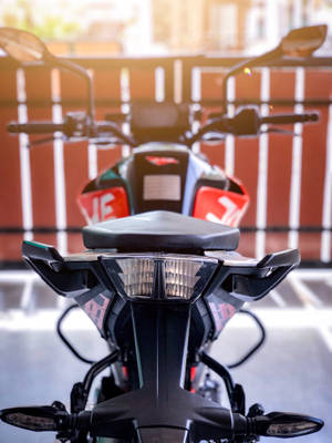 帶有紅色點綴的黑色電單車在日落時停泊在戶外。 — Bobber電單車 壁紙