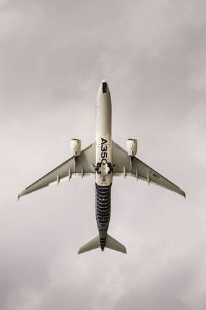 從下方觀看空中巴士A350飛機，背景為多雲天空。 — 雲朵 壁紙