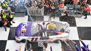 NASCAR車手在格子旗終點線用五彩紙屑和香檳慶祝勝利。