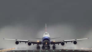 一架大型飛機在暴風雨的天空下降落在潮濕的跑道上。 — 飛機 壁紙