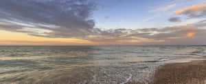 海洋上的夕陽，卵石海灘上的海浪