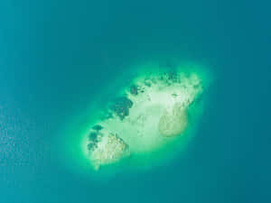 從上方俯瞰碧綠海水中的一個小珊瑚島。