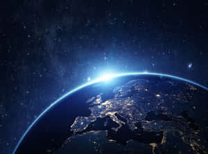 從太空看到的地球，帶有城市燈光和日出地平線。 — 行星 壁紙