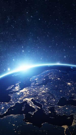 從太空夜晚看到的地球，城市燈光與地平線上的日出。 — 行星 壁紙