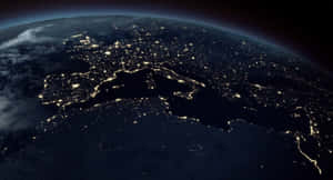 從太空俯瞰地球的夜景，城市燈光照亮大陸和海洋。 — 星際寶貝 壁紙