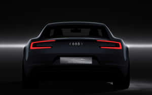 在黑暗的攝影棚中，時尚黑色Audi e-tron電動車帶有發光的紅色尾燈。 — Audi R8 GIF 壁紙