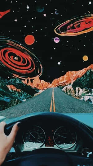 手握方向盤，在宇宙天空下穿越山脈的道路上行駛，天空中有星系。 — 植物美學 壁紙