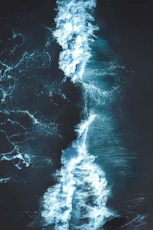 從空中拍攝的洶湧海浪路徑，白色泡沫在深藍色海水中翻騰。 — 海浪 壁紙