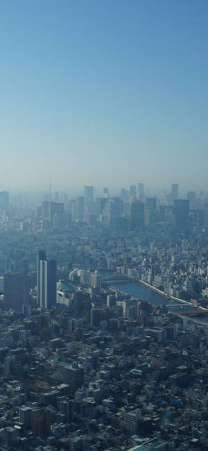 東京城市景觀，河流和摩天大樓在清澈藍天下。