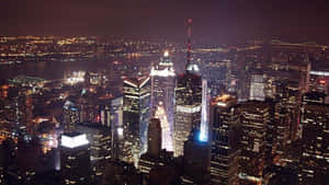 紐約市高樓大廈和橋樑在夜間亮燈的空中景觀。