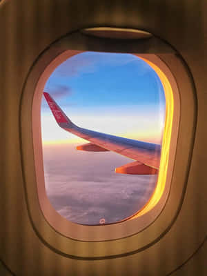 透過窗戶看到亞洲航空飛機機翼在日落時分雲層上方。 — 天空景觀 壁紙