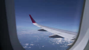 透過窗戶看到雲層上的飛機機翼 — 天空景觀 壁紙