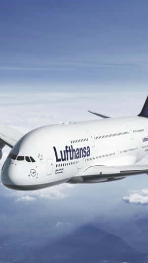 漢莎航空空中巴士A380在雲層上方飛行，遠方有山脈。 — 天空景觀 壁紙