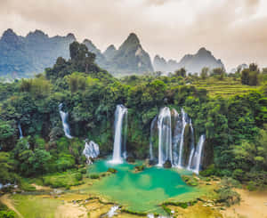 瀑布傾瀉入茂密叢林和高山中的碧綠色水池。 — 湖 壁紙