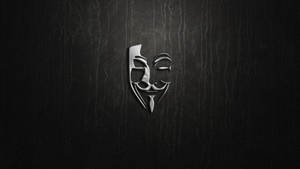 在深色紋理皮革背景上的銀色蓋伊·福克斯面具