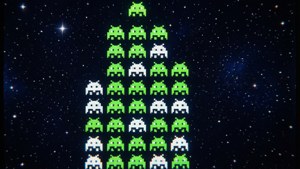 像素化的綠色和白色外星人在星空下排列成金字塔形狀。