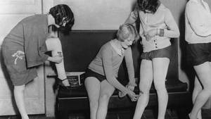 四位女性在復古更衣室佩戴腿部綁帶。