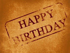 Happy Birthday 用紅色墨水印在紋理棕色紙上。